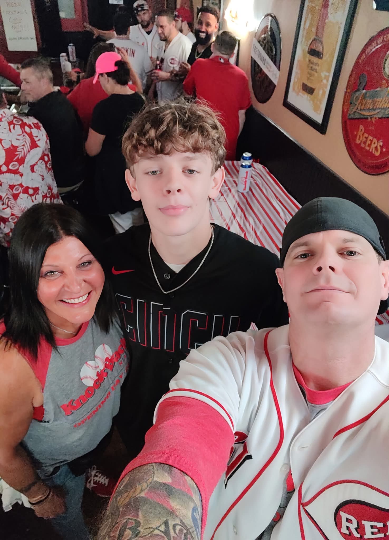 A family selfie in Reds gear inside the bar