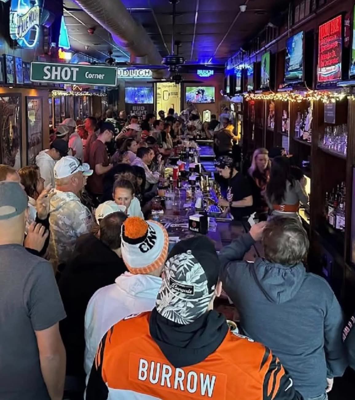 A packed crowd at the bar on game day under the Shot Corner sign