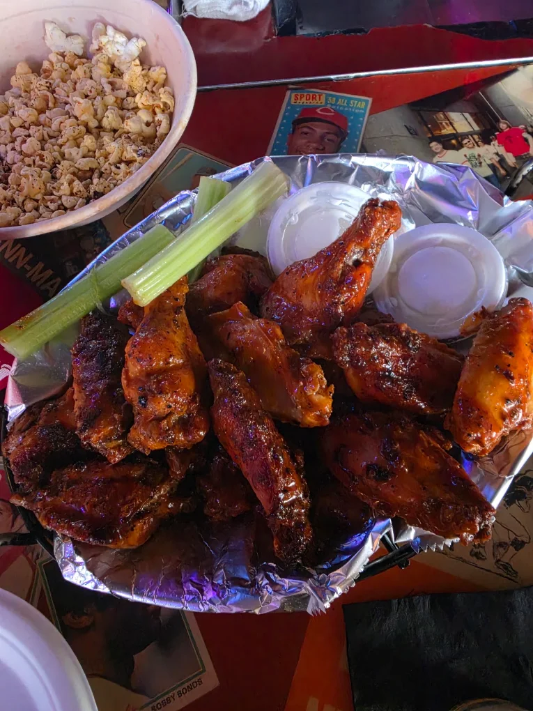 A basket of Knockback Nat's smoked chicken wings with celery and dipping sauce